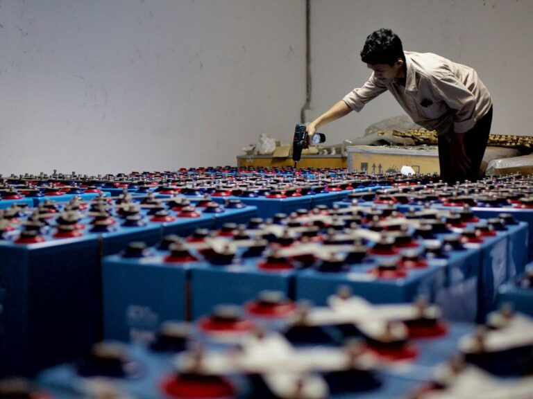 Rows of battery storage cells being inspected in an energy storage facility